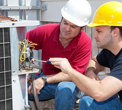 Two men working on an electric panel