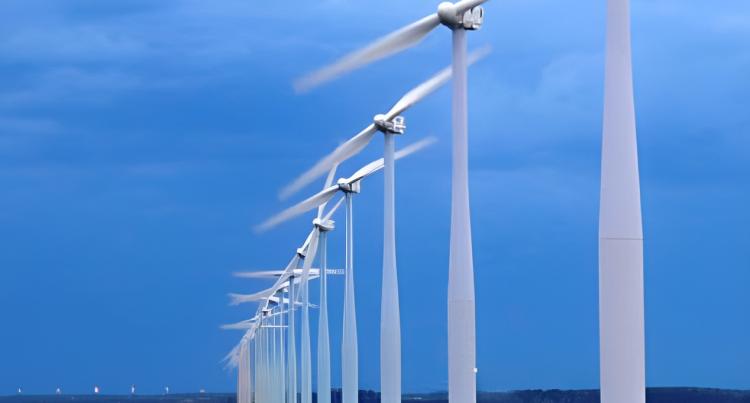 a row of wind turbines stretching to  the horizon